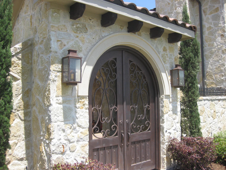 Copper Aspen lanterns hung beside a very intricately woven gatehouse door