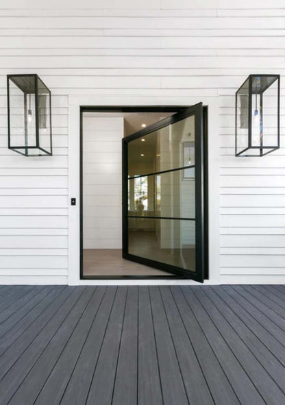Black finished Ashley lanterns mounted outside of a doorframe with a slightly open glass door