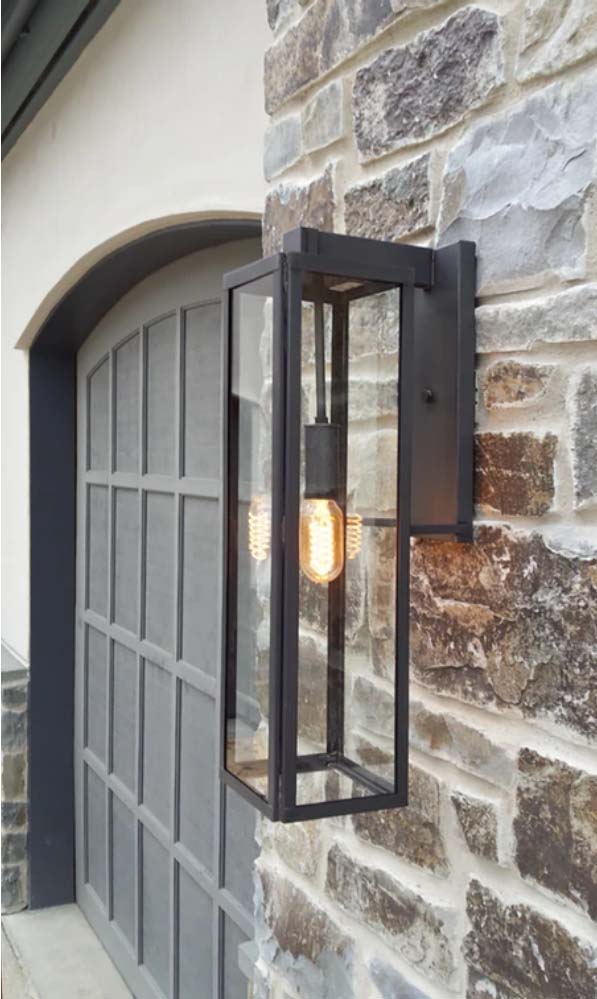 The Ashley lantern featured hanging outside of a garage door with a dark finish