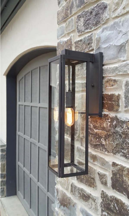 The Ashley lantern featured hanging outside of a garage door with a dark finish