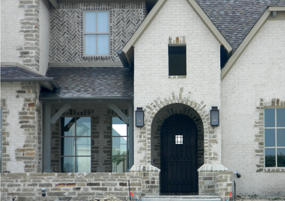 Two Aspen lanterns hung outside of the front door of a brick style house