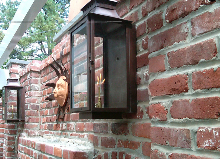 The side profile of the Aspen featured as a gas lantern hung on a brick wall