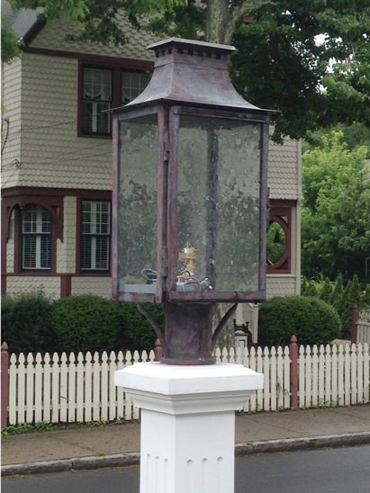 The Aspen lantern featured on a post mount with water glass